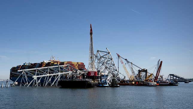 A photo of the Dali ship under the wreckage of a bridge. 